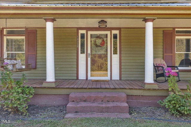 view of exterior entry featuring covered porch