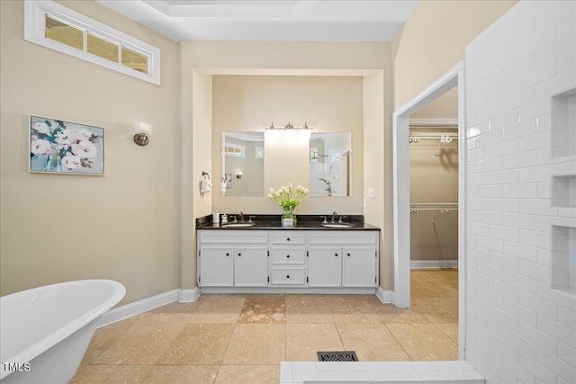 bathroom with a tub to relax in, tile patterned floors, and vanity