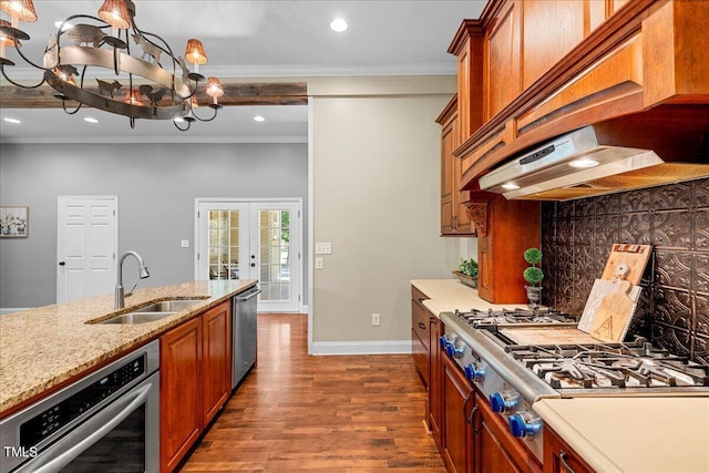 kitchen with exhaust hood, a notable chandelier, crown molding, appliances with stainless steel finishes, and sink