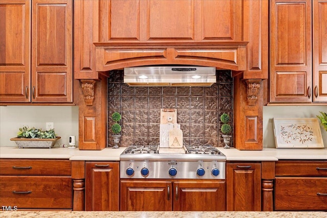 kitchen featuring stainless steel gas stovetop, backsplash, and ventilation hood