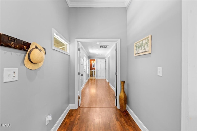 hallway with hardwood / wood-style floors and crown molding