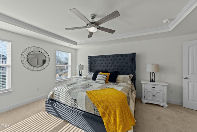 carpeted bedroom featuring a tray ceiling, multiple windows, ceiling fan, and ornamental molding