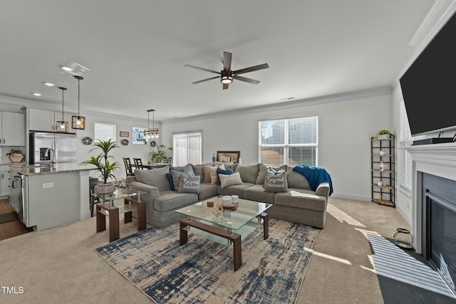 carpeted living room featuring ceiling fan and ornamental molding