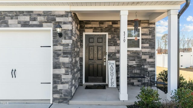 doorway to property featuring covered porch and a garage