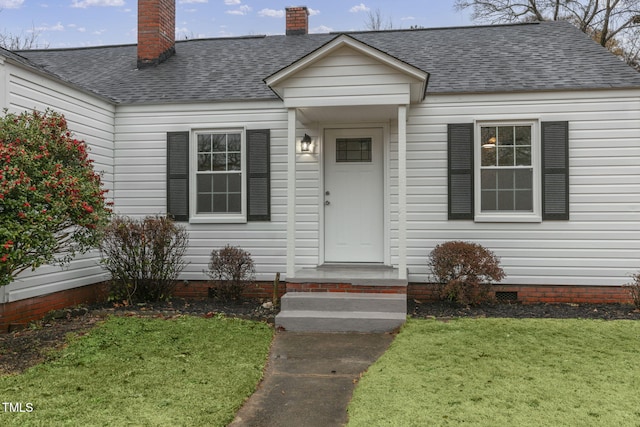 doorway to property with a lawn