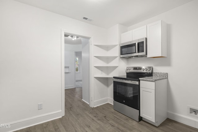 kitchen with hardwood / wood-style floors, stainless steel appliances, and white cabinetry