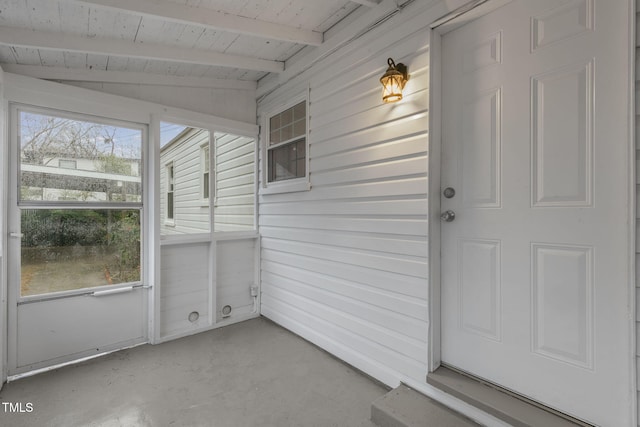 unfurnished sunroom featuring vaulted ceiling with beams, plenty of natural light, and wooden ceiling