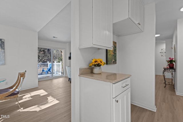 kitchen featuring light wood-type flooring and white cabinetry