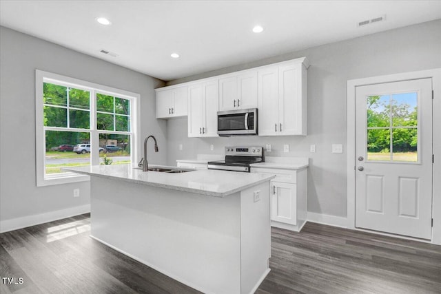 kitchen featuring white cabinetry, dark hardwood / wood-style flooring, an island with sink, and stainless steel appliances