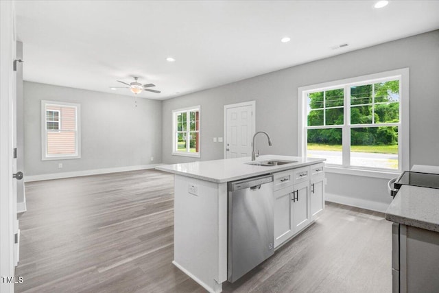 kitchen featuring dishwasher, white cabinets, a center island with sink, sink, and ceiling fan