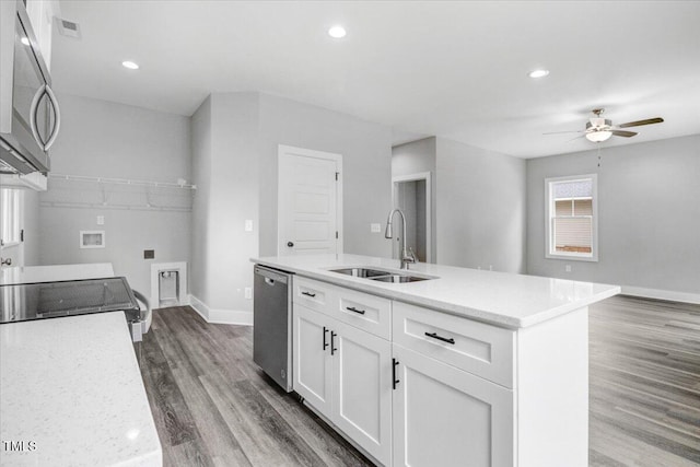 kitchen with stainless steel appliances, ceiling fan, a kitchen island with sink, sink, and white cabinets