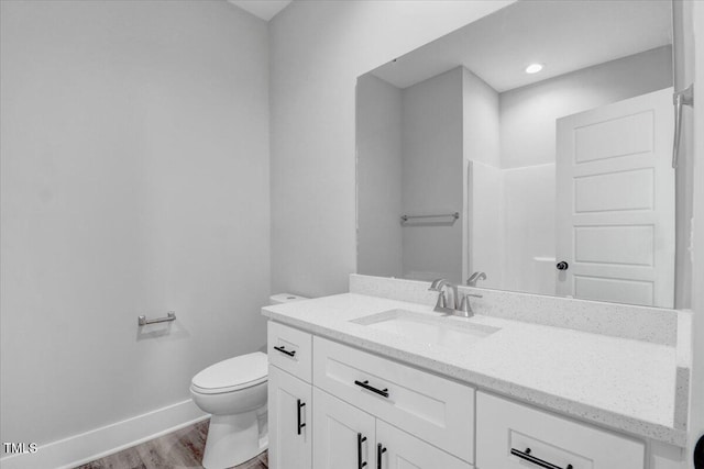 bathroom featuring hardwood / wood-style flooring, vanity, and toilet