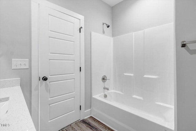 bathroom featuring wood-type flooring, vanity, and shower / washtub combination