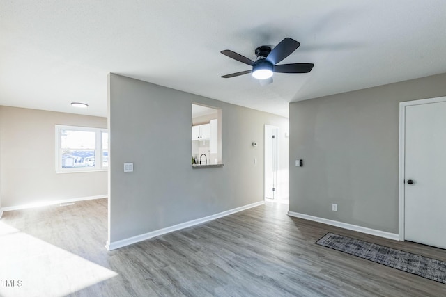 spare room featuring ceiling fan, light hardwood / wood-style floors, and sink