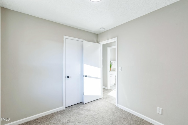 unfurnished bedroom with light carpet and a textured ceiling