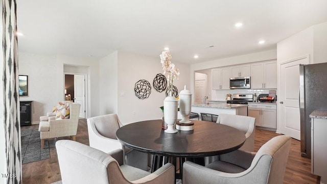 dining area with hardwood / wood-style floors and sink