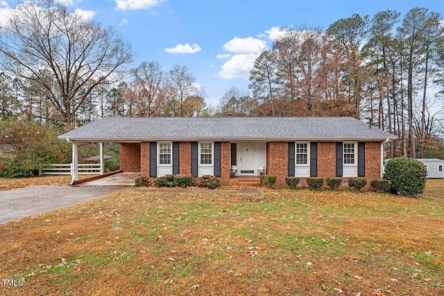 ranch-style house featuring a carport and a front lawn