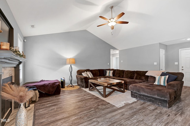 living room with a fireplace, ceiling fan, hardwood / wood-style floors, and vaulted ceiling