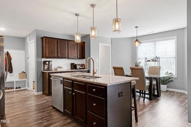 kitchen featuring a center island with sink, decorative light fixtures, dark hardwood / wood-style flooring, and sink