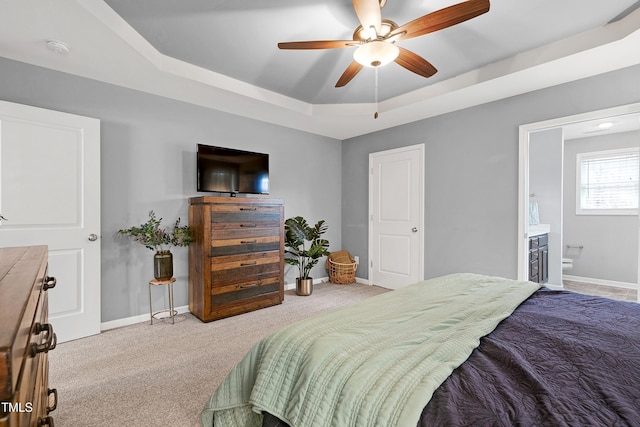 bedroom with ceiling fan, a raised ceiling, and light carpet