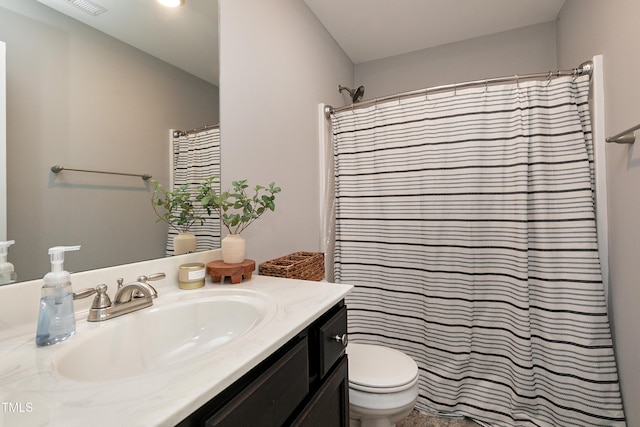 bathroom featuring curtained shower, vanity, and toilet