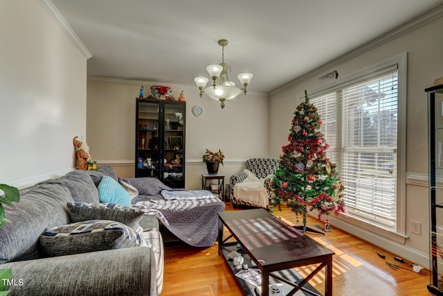 living room featuring light hardwood / wood-style flooring, ornamental molding, and an inviting chandelier