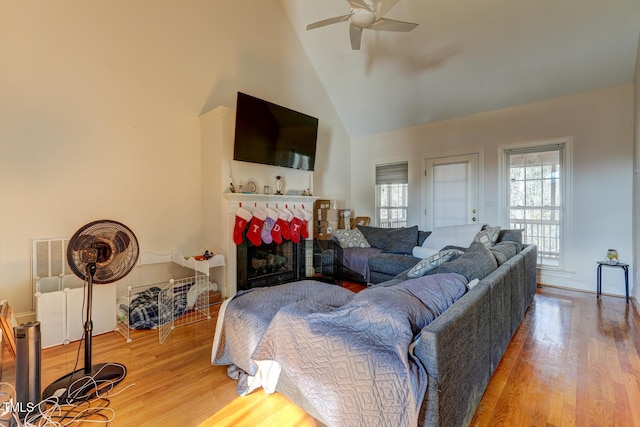 living room featuring ceiling fan, wood-type flooring, and high vaulted ceiling