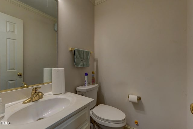 bathroom with vanity, toilet, and ornamental molding