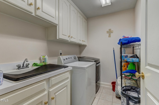 washroom featuring cabinets, separate washer and dryer, sink, and light tile patterned floors