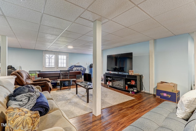 living room with hardwood / wood-style floors and a drop ceiling