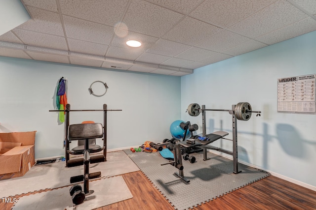 exercise room with hardwood / wood-style floors and a drop ceiling