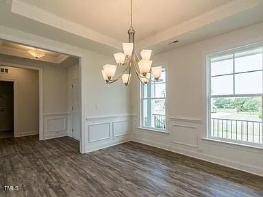 unfurnished dining area featuring a notable chandelier, dark hardwood / wood-style floors, and a raised ceiling