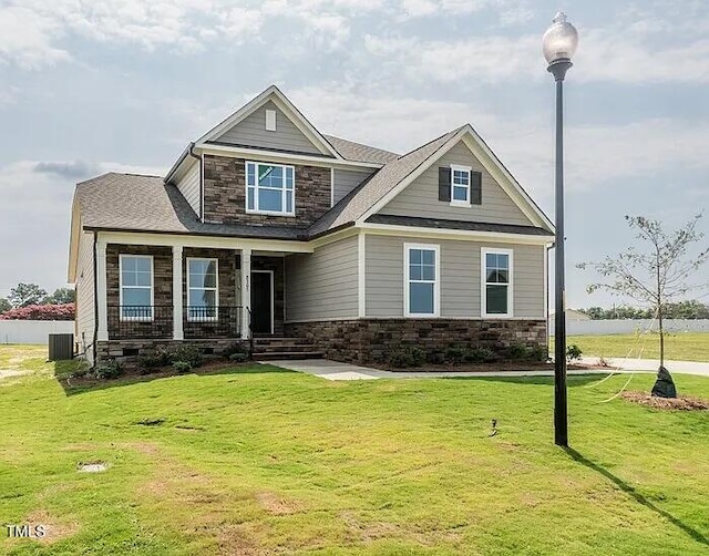 craftsman house featuring a porch, central air condition unit, and a front yard