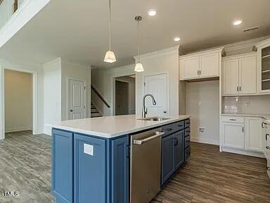 kitchen with pendant lighting, a center island with sink, dishwasher, dark hardwood / wood-style floors, and white cabinetry