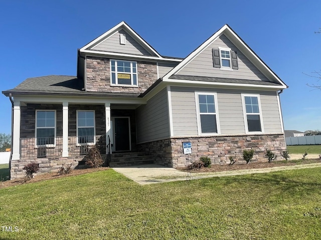 craftsman house with a front yard and stone siding