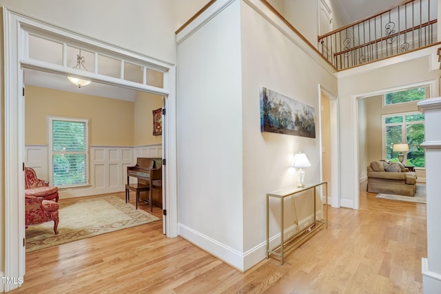 hallway featuring light wood-type flooring and a high ceiling