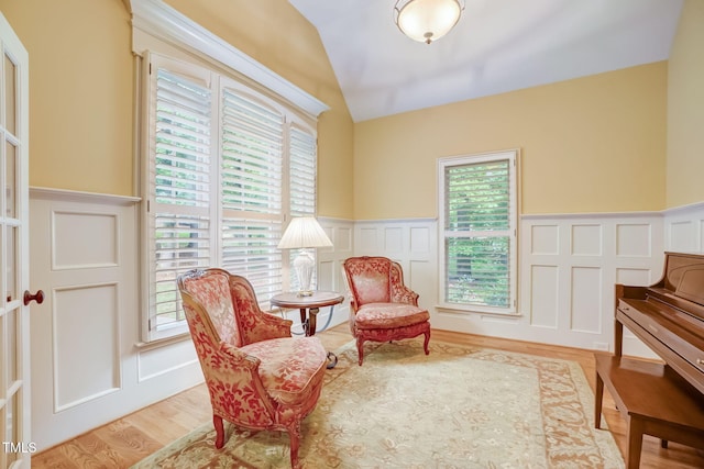 sitting room featuring light wood-type flooring and vaulted ceiling