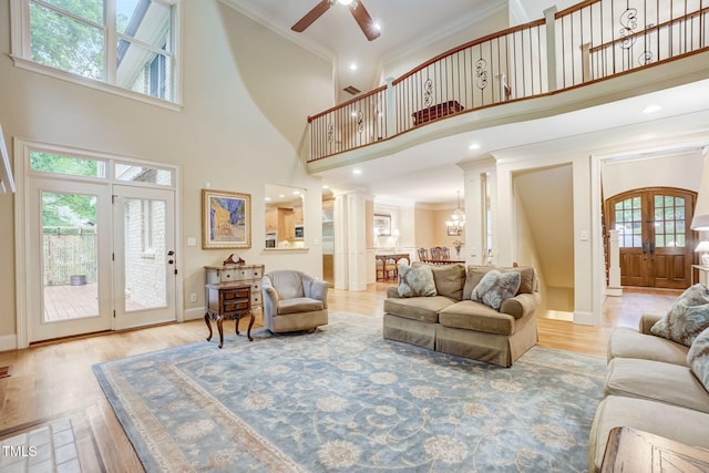 living room with decorative columns, a wealth of natural light, and a towering ceiling