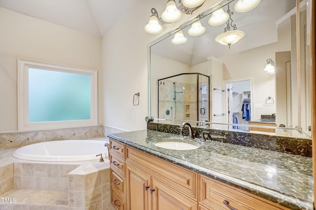 bathroom featuring independent shower and bath, vanity, and lofted ceiling