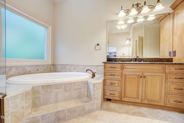 bathroom with tiled tub, tile patterned floors, and vanity