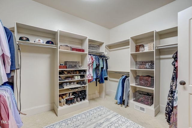 spacious closet featuring light colored carpet