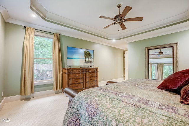 carpeted bedroom with ceiling fan, crown molding, and a raised ceiling