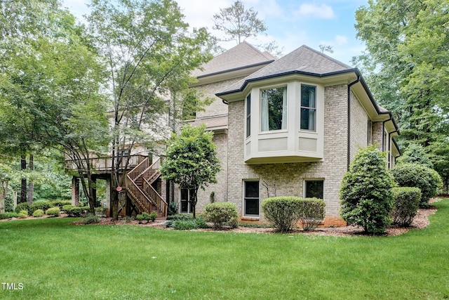 exterior space featuring a wooden deck and a lawn