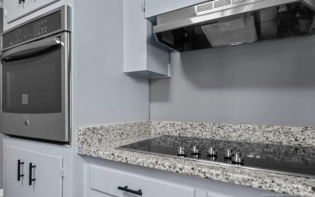 kitchen featuring white cabinetry, black electric stovetop, and oven