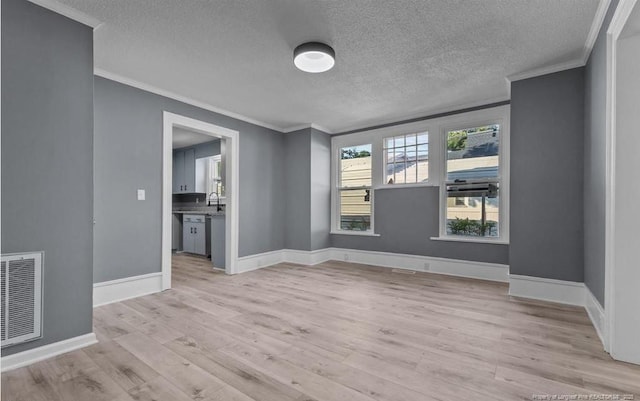 unfurnished living room with crown molding, light hardwood / wood-style flooring, and a textured ceiling