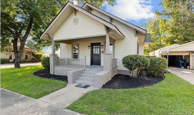 bungalow-style house with a porch, a carport, and a front yard