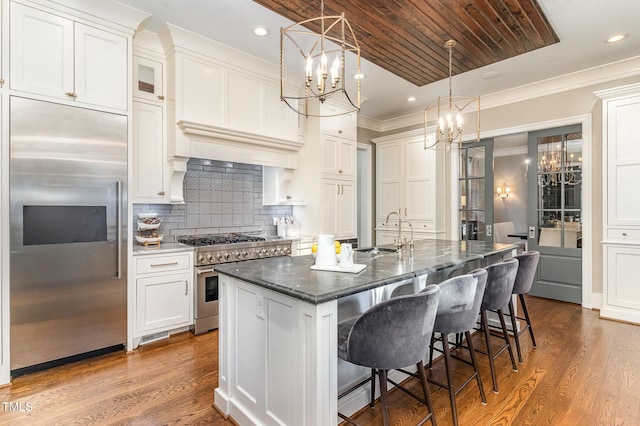 kitchen featuring sink, hardwood / wood-style flooring, high quality appliances, and an island with sink