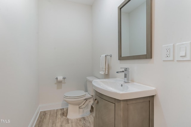 bathroom featuring wood-type flooring, vanity, and toilet