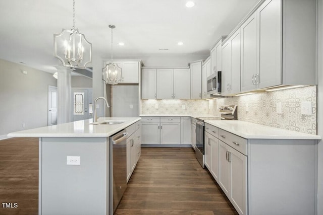 kitchen featuring dark hardwood / wood-style floors, white cabinetry, sink, a kitchen island with sink, and stainless steel appliances