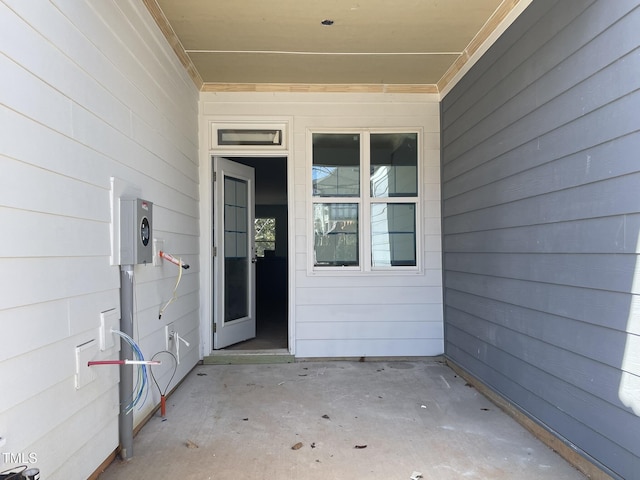 view of exterior entry with a patio area